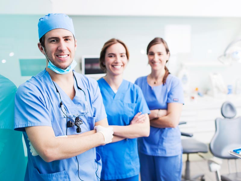 three dental professionals smiling