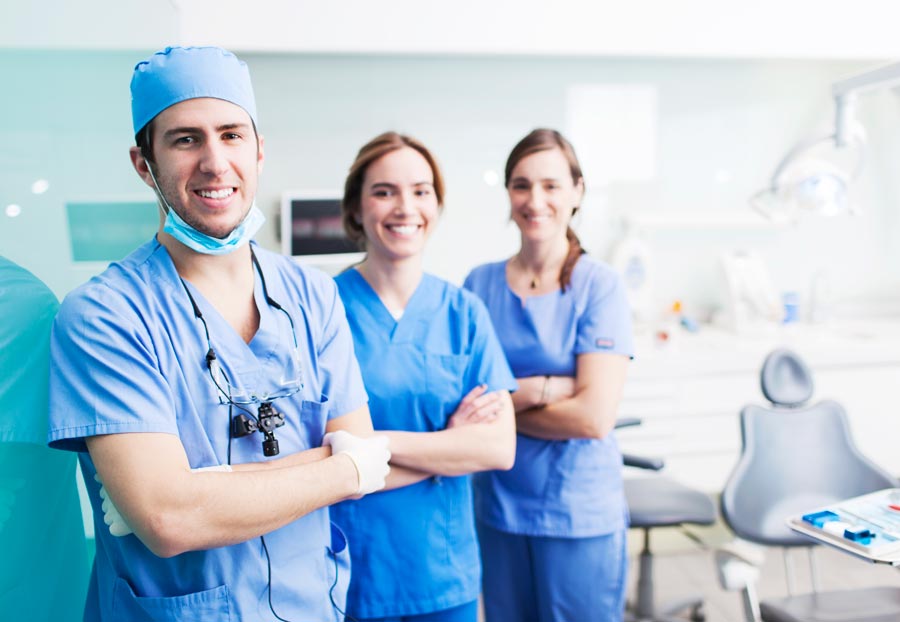 three dental professionals smiling